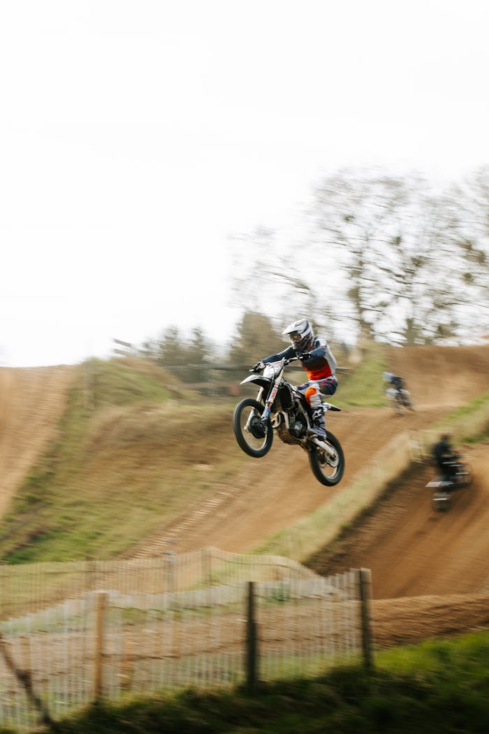 Rider performing a thrilling jump on a motocross track in Germany, showcasing the adrenaline of extreme sports.