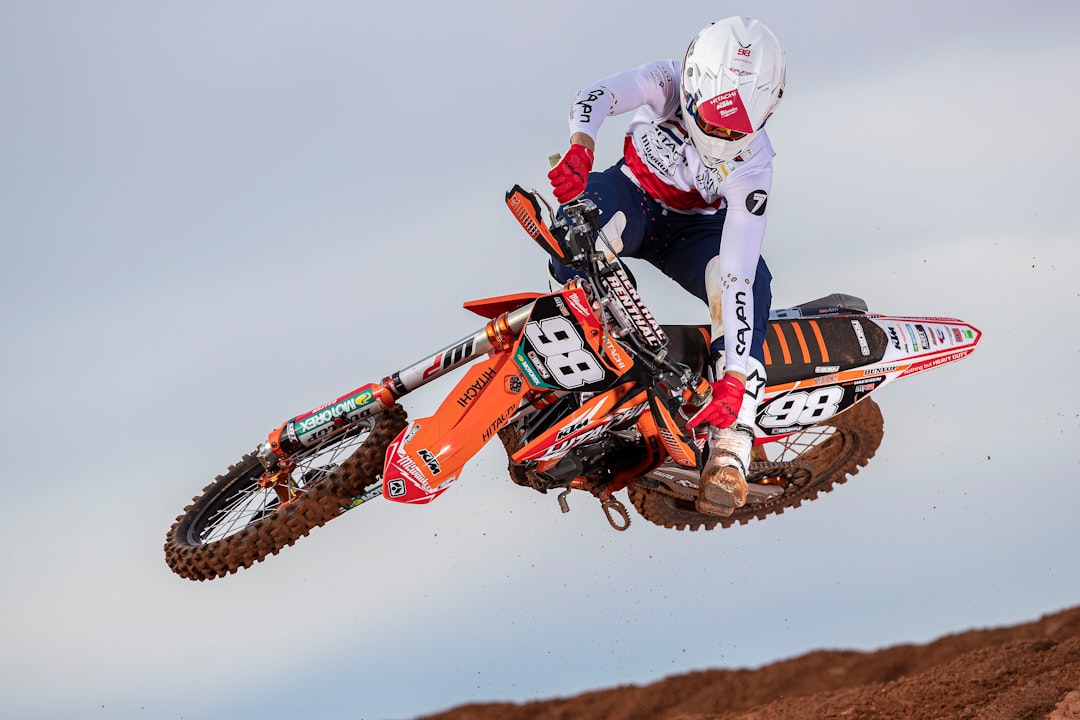 man-in-red-and-white-motocross-helmet-riding-motocross-dirt-bike-ecv40eg4blq